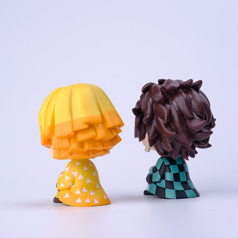Two figures from the Demon Slayer Figure Set feature yellow hair with a matching outfit of white triangles, and dark hair with a green and black checkered pattern. Perfect against any plain backdrop, they add charm to any anime collection.