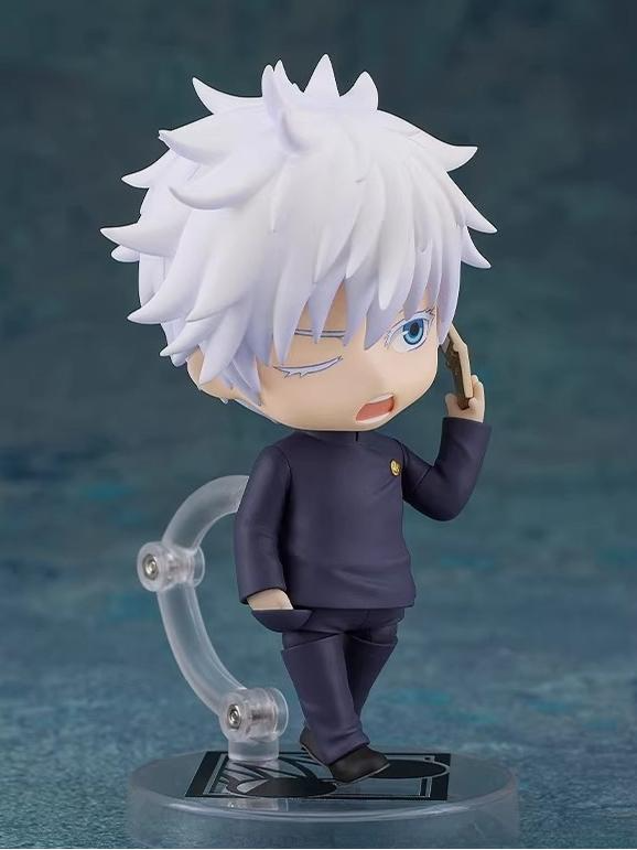The Gojo Satoru Action Figure from Jujutsu Kaisen is a 12cm chibi-style collectible featuring white spiky hair and a black outfit. It has movable joints, stands on an adjustable base, and depicts Gojo holding a phone to his ear while winking.