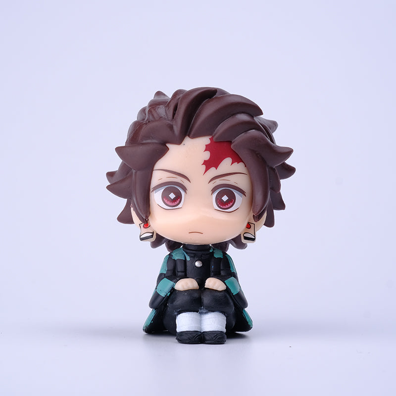 This 7cm chibi-style figure from the Demon Slayer Figure Set - 8-Piece PVC Anime Collection showcases a character with spiky dark hair, a red forehead mark, large red eyes, and a green and black outfit, seated with hands in lap against a white backdrop.