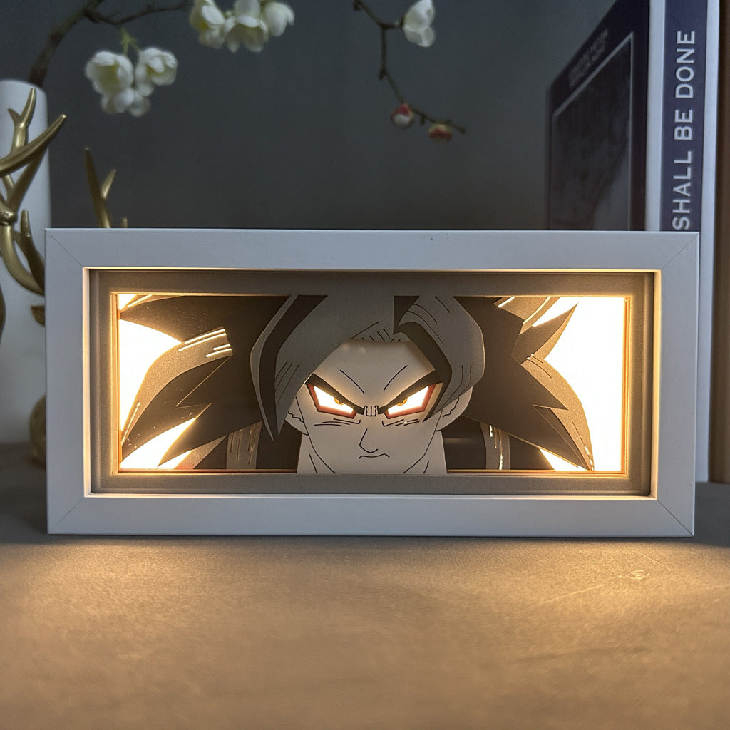 The Seakoff Dragon Ball Z Anime Light Box features a 3D LED lamp of Goku in Ultra Instinct with spiky hair and glowing eyes. Dynamic color-changing effects highlight the intense expression against a backdrop of a plant and "SHALL BE DONE" book, perfect for any DBZ fan.