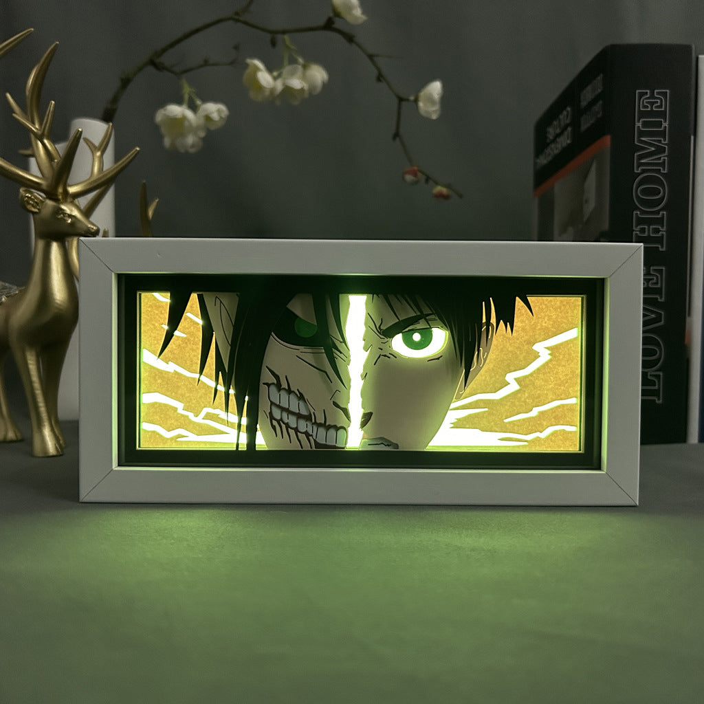 The Eren Yeager Attack on Titan 3D LED Light Box by Attack on Titan features half-human, half-skeletal imagery. A decorative deer figure and a book titled "LOVE HOME" are in the background.