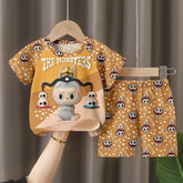 The LABUBU Baby Pajama Set - "The Monsters" features a playful monsters theme, with a light brown short-sleeve shirt and shorts, made from milk silk. The shirt highlights a large toy-like monster graphic and the whimsical text "The Monsters.