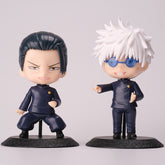 Two chibi-style figures from the Gojo Satoru & Suguru Geto 10-Piece Action Figure Set stand on bases, perfect for any anime collection. One features short dark hair and a confident expression, while the other resembles an action figure with spiky white hair, blue glasses, and a smile. Both wear dark uniforms.