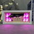 A 16-color adjustable LED JoJo’s Bizarre Adventure Anime Light Box showcases Jotaro Kujo with an intense expression and glowing pink hand symbols. Nearby, a decorative deer sculpture and the book "That Justice Shall Be Done" complete the scene.