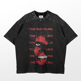 The Colossal Titan Rumbling T-Shirt by Attack on Titan features a striking red open-mouthed face graphic and "THE RUMBLING" text on black, washed fabric with a slightly distressed look for an edgy style.