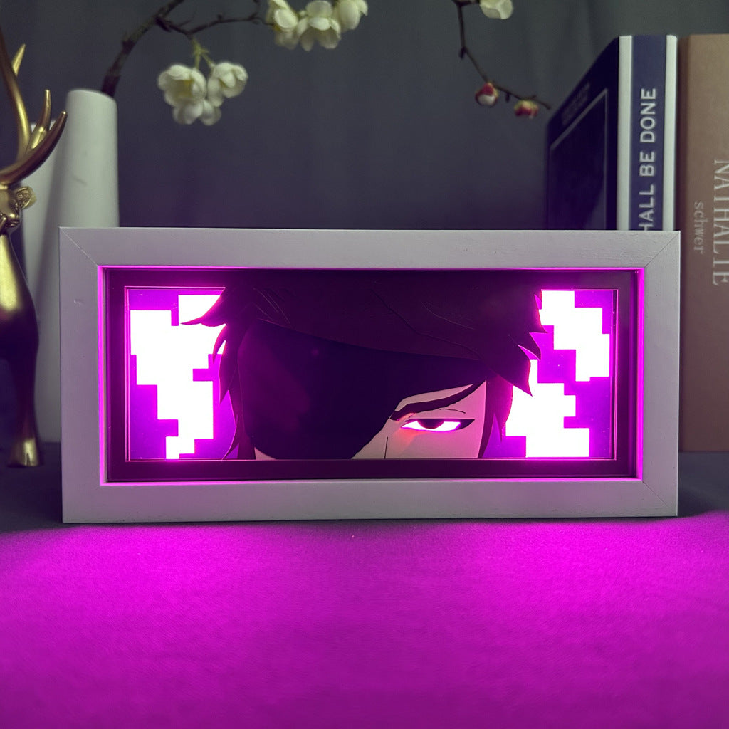 The Seakoff One-Eyed Anime Light Box – Mysterious Glow with 16-Color LED, features a vibrant pink and purple design. Perfect for placing on surfaces alongside books and decorative branches, it adds a creative touch to any space.