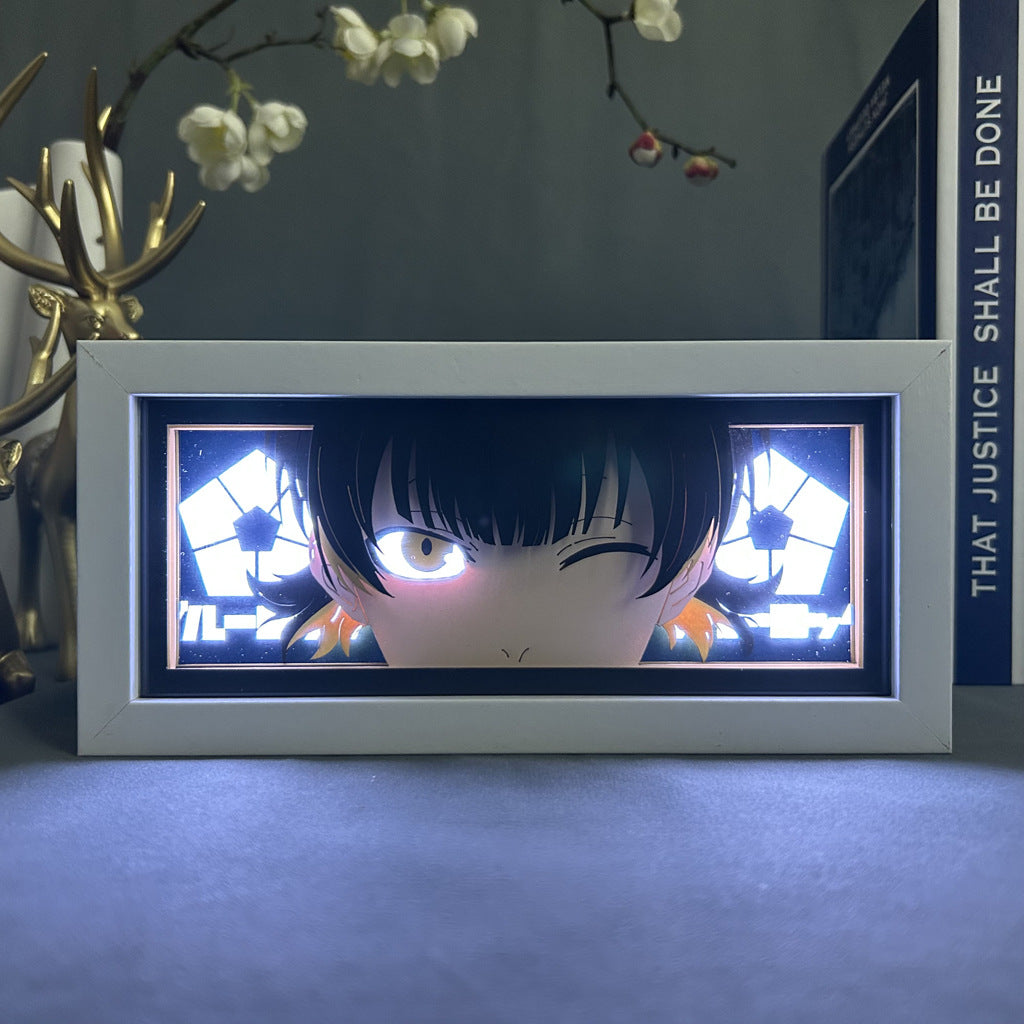 The Tamaki Kotatsu Anime Light Box–Fire Force Winking Flame Design by Fire Force features Tamaki winking with short black hair and yellow accents. It is displayed alongside a decorative antler sculpture and a book titled "THAT JUSTICE SHALL BE DONE" in the background.
