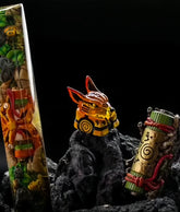 A collection of decorative items on black rocks includes the vibrant Naruto Ninja Keycaps Set, featuring designs like a vertical object with colorful patterns resembling a scroll, a fox-eared figurine with a yellow body representing Kurama and tailed beasts amidst the dark-themed setup.