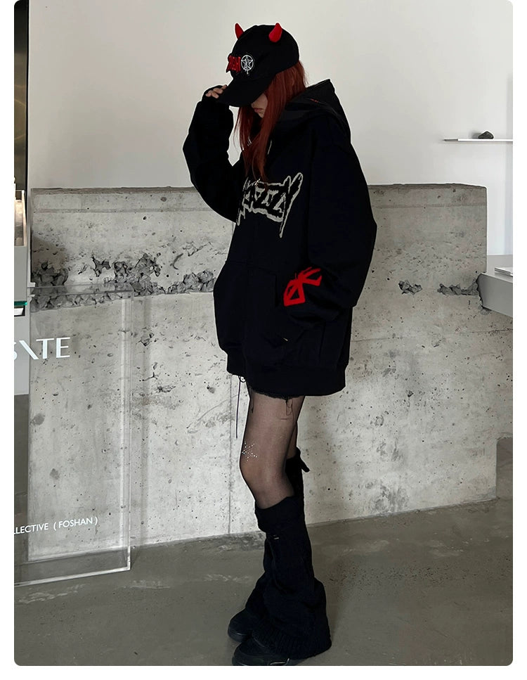 Wearing a Berserk-inspired Griffith Dark Knight Hoodie, a person in black knee-high leg warmers and dark shorts stands against a concrete wall. The look is completed with sheer black stockings and a cap featuring red horns, emphasizing the minimalist urban style.