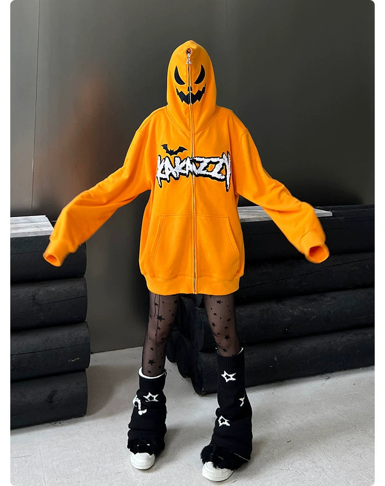 In a dimly lit setting, someone wears an oversized Seakoff Halloween Pumpkin Hoodie, complete with a jack-o&