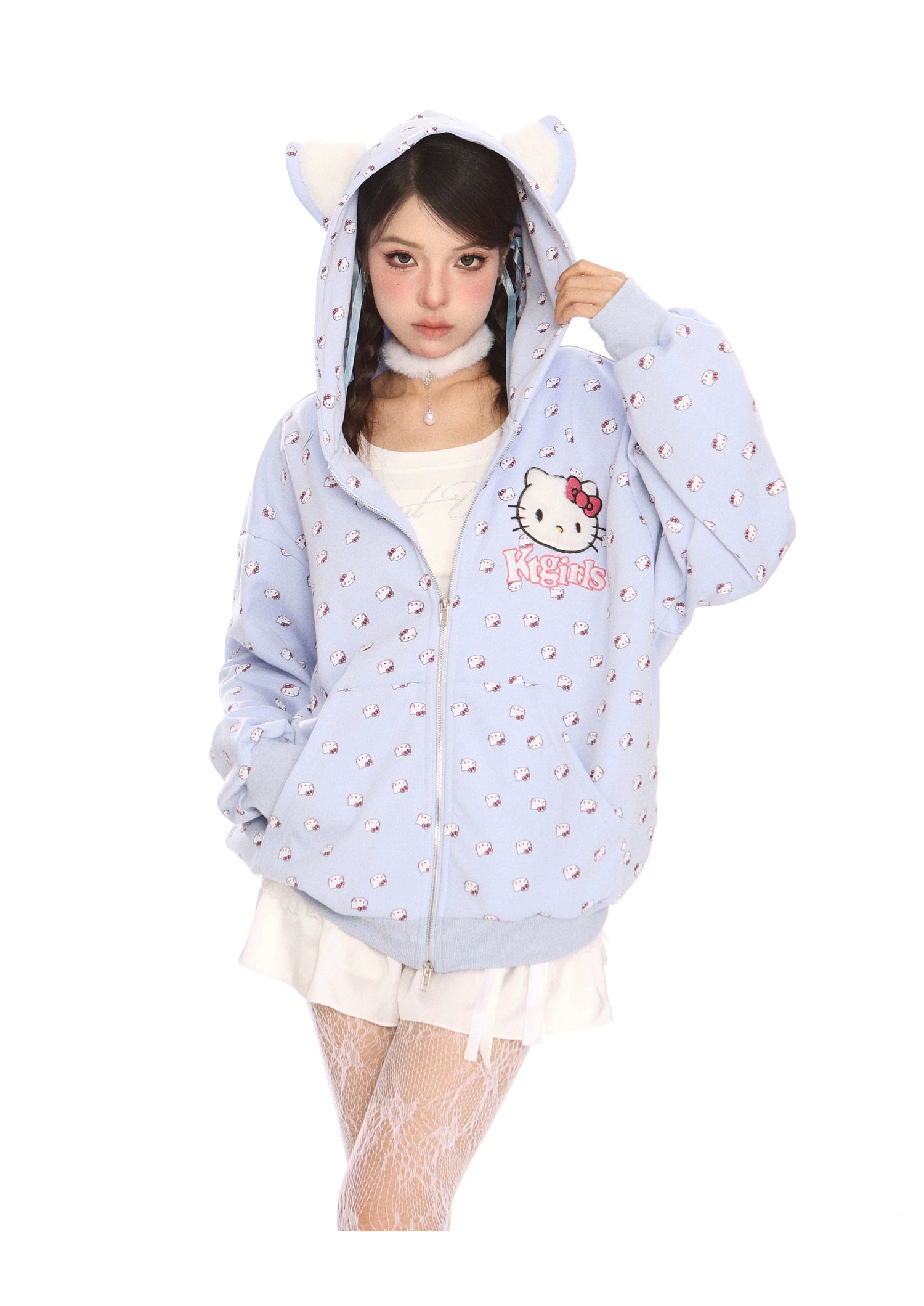 Dressed in kawaii fashion, a person wears the Hello Kitty Pink Kawaii Hoodie from Seakoff, featuring a cat ear hood and all-over print. They pair it with a white skirt and lace stockings to complete the adorable ensemble.