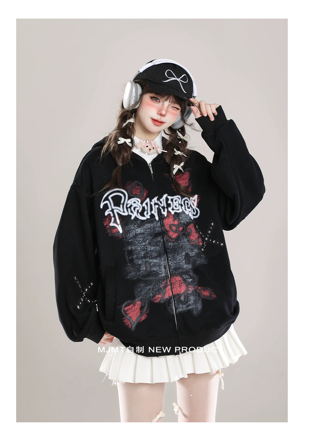 Dressed in a Seakoff Gothic Hello Kitty Princess Hoodie with edgy heart and cross graphics, headphones, and a black cap, a person poses with one hand on their hat. With braided hair over a white collared shirt and pleated skirt, they perfectly blend kawaii style with an alternative twist.