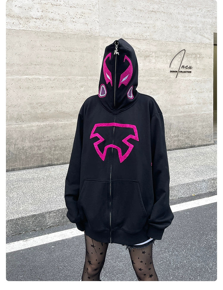 A person in a Seakoff Futuristic Warrior Hoodie - 400GSM Oversized Sci-Fi Pink and Black Zip-Up Sweatshirt obscures their face against a concrete wall, complemented by star-patterned tights. The "Incu Mini Collection" signature graces the background.