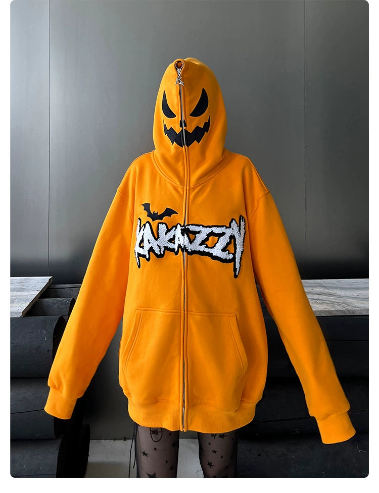 A person in a Seakoff Halloween Pumpkin Hoodie, an oversized orange zip-up sweatshirt with a black jack-o&