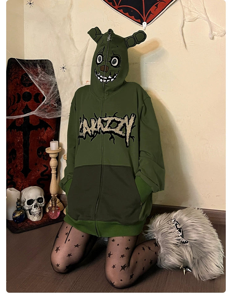 Kneeling in a Seakoff Springtrap-Inspired Hoodie—an oversized green zip-up sweatshirt from Five Nights at Freddy&