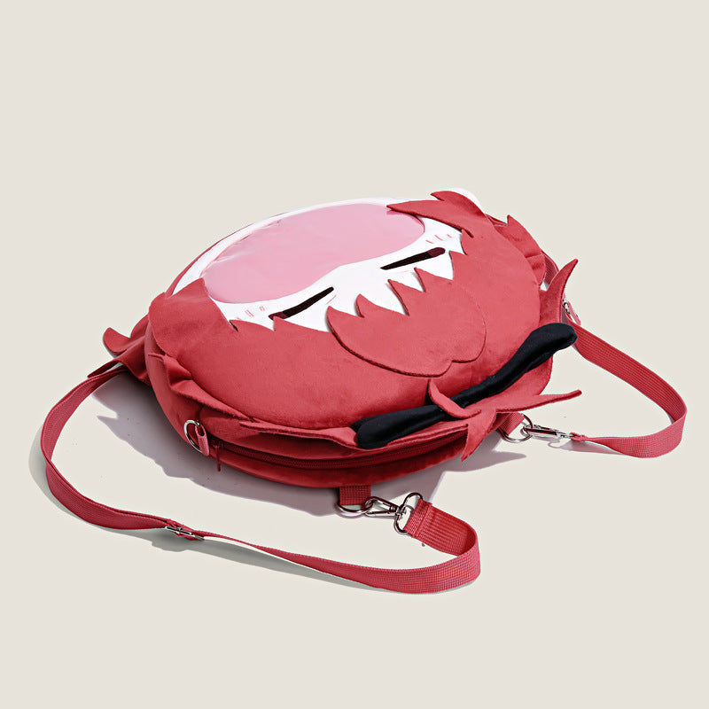 The Seakoff Madoka Magica Kyoko Sakura Plush Shoulder Bag showcases a light background with red straps, a decorative bow, and a playful cartoon face featuring large eyes. Inspired by Kyoko Sakura, it includes a unique transparent mouth pocket for fans seeking a fun anime fashion statement.