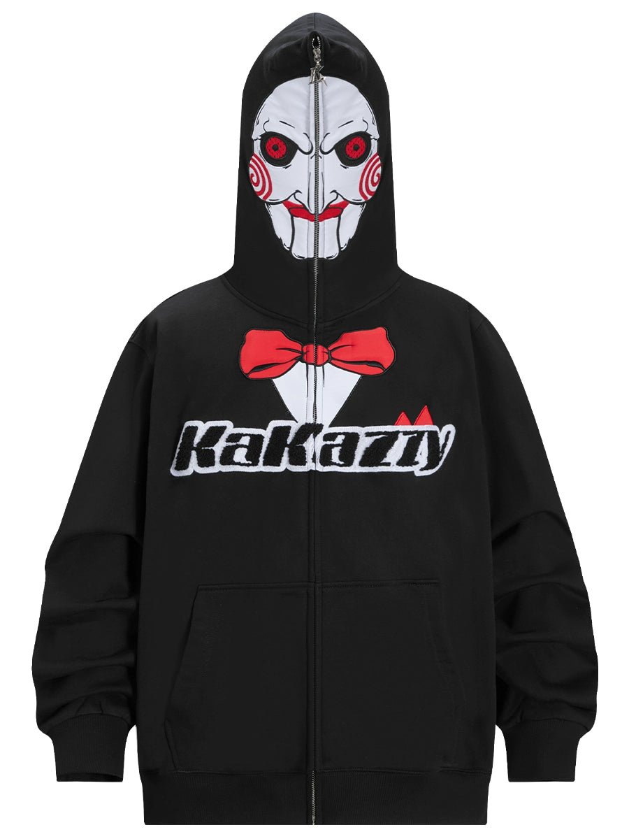 The Seakoff Saw-Inspired Hoodie is a 400GSM oversized black zip-up perfect for horror fans, featuring a Billy the Puppet-style face with red eyes, swirled cheeks on the hood, a red bowtie design, and "Kakazzy" across the chest.