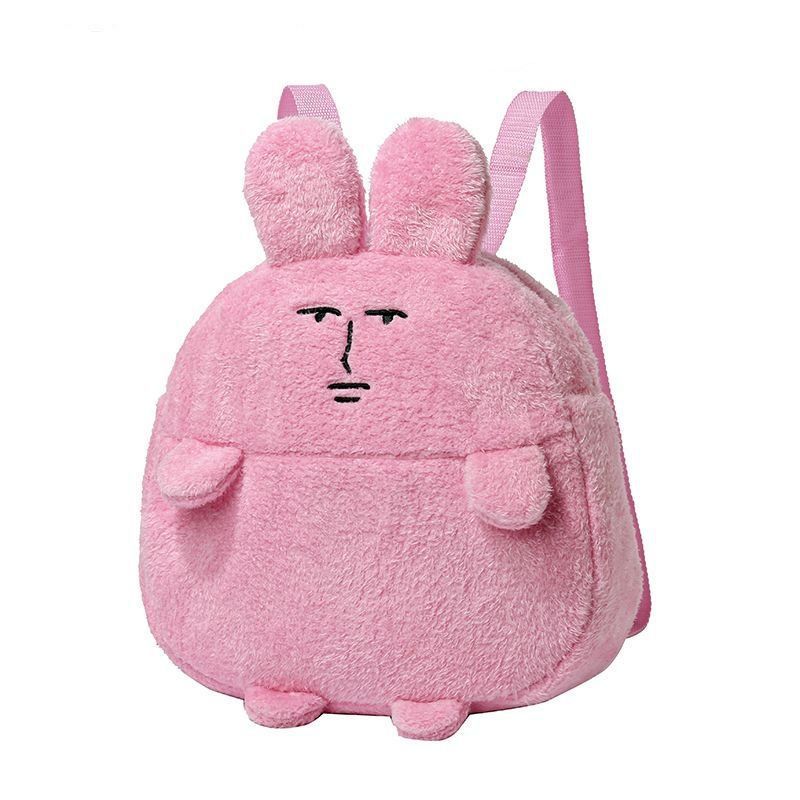The Seakoff Quirky Pink Bunny Plush Backpack offers a fun twist with its plush texture, grumpy expression, two small ears on top, and pink adjustable straps, making it a unique everyday accessory.