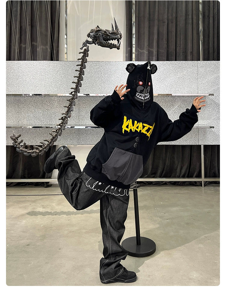 Inside, someone models the Seakoff Dark Bear Demon Hoodie made for horror fans. Made of 400GSM cotton, it features a black bear theme with "KARAZY" in yellow and a dragon-like hood spine. Standing on one leg with arms spread adds an eerie touch.