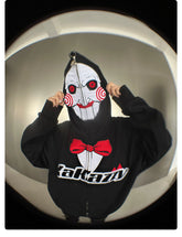 Someone wears a Seakoff Saw-Inspired Hoodie, a black oversized zip-up with Billy the Puppet&