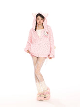 A person stands against a white background wearing a Seakoff Hello Kitty Pink Kawaii Hoodie, an oversized zip-up with cat ears and all-over bear print, paired with white lace stockings and furry shoes. With long hair, they gaze directly at the camera.