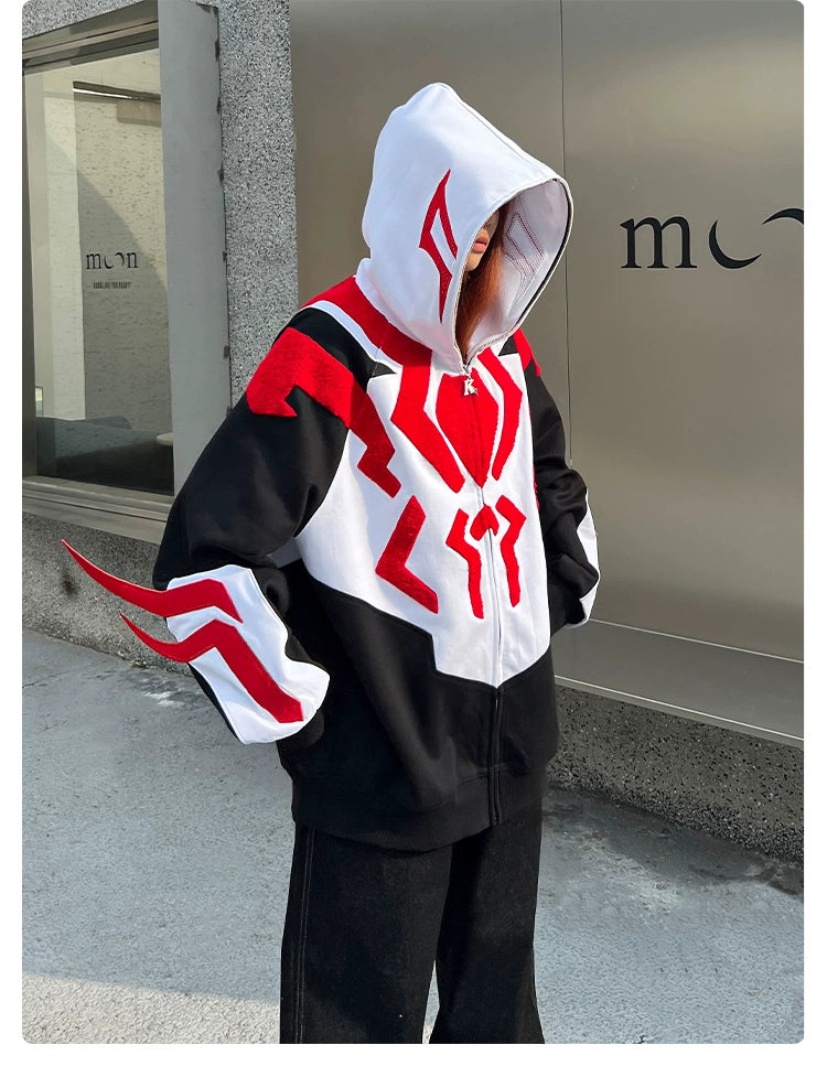 A person wearing a Seakoff Superhero-Inspired Hoodie, a 400GSM oversized black, red, and white zip-up streetwear sweatshirt featuring bold graphic patterns, stands against a textured wall near a partial sign reading "mo," with the hood up and their face obscured. Perfect for comic book fans!.