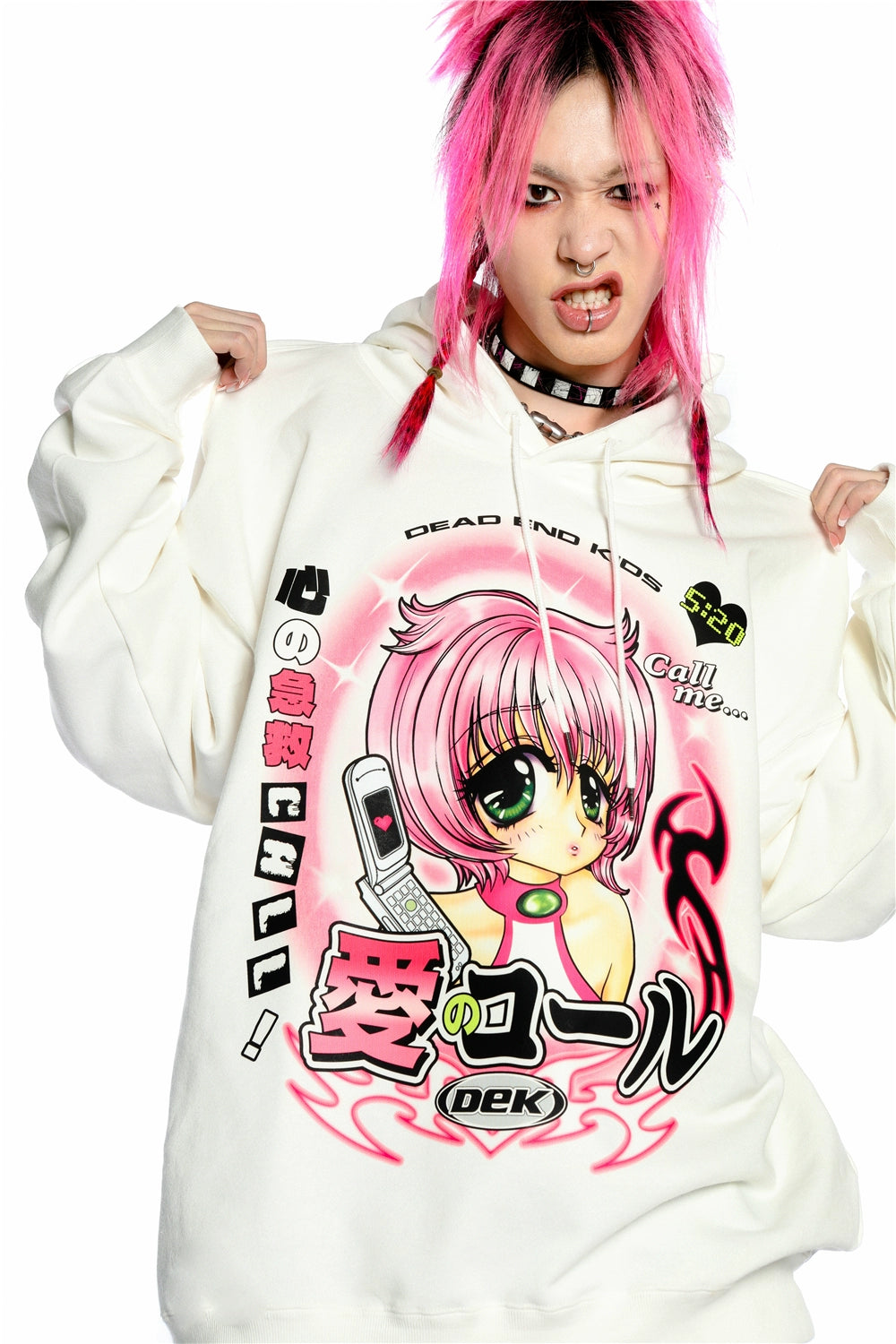 A person with pink hair poses fiercely in a Seakoff Y2K Aesthetic Anime Hoodie. The white pullover flaunts a retro manga girl graphic, big eyes, and a kawaii phone design. Flames and Japanese text add flair with "Dead End Kids.
