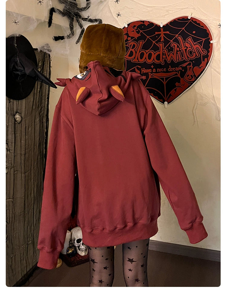A person in a Seakoff Foxy-Inspired Hoodie, a brown bear hat, and star-patterned tights stands with their back to the camera. Halloween decorations adorn the wall, including a large spider and a "Blood Witch" sign—ideal for fans of Five Nights at Freddy&