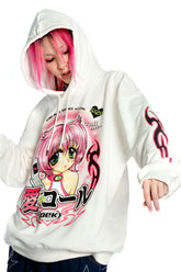 A pink-haired person sports a Seakoff Y2K Aesthetic Anime Hoodie featuring a kawaii retro manga girl graphic and flaming sleeves, enriched with text and phone design elements on its white canvas.
