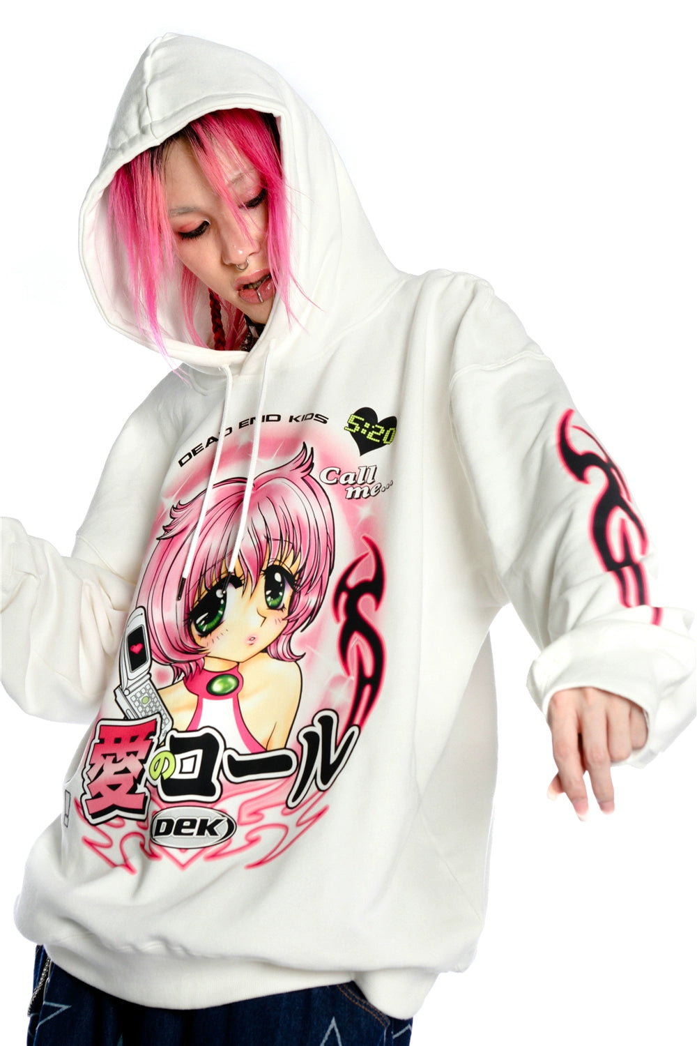A pink-haired person sports a Seakoff Y2K Aesthetic Anime Hoodie featuring a kawaii retro manga girl graphic and flaming sleeves, enriched with text and phone design elements on its white canvas.
