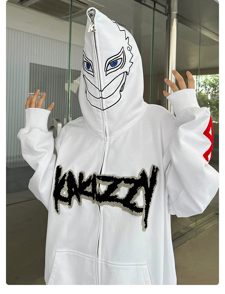 Wearing a Berserk Griffith-Inspired Hoodie, an oversized white 400GSM zip-up from the Berserk brand, someone hides their face with the graphic mask design on the hood and bold "AKIZZY" lettering. Evoking Berserk fans, they pose with hands raised like Griffith in Brand of Sacrifice.