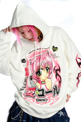 A person with pink hair and kawaii style adjusts the hood of their white Seakoff hoodie, adorned with vibrant anime artwork of large-eyed characters and Japanese text, capturing the nostalgic charm of Y2K aesthetic.