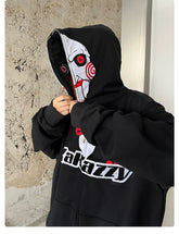 A person adjusts the hood of a Seakoff Saw-Inspired Hoodie, a black oversized zip-up sweatshirt featuring Billy the Puppet&