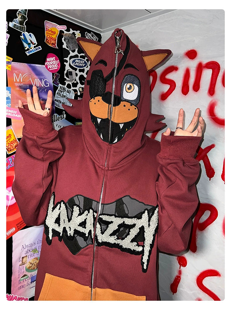 Donning a Seakoff Foxy-Inspired Hoodie, an oversized red zip-up sweatshirt, the wearer gestures upwards. "ANARCHY" stands boldly on the hoodie amid a sticker-filled background with red text, evoking Five Nights at Freddy&