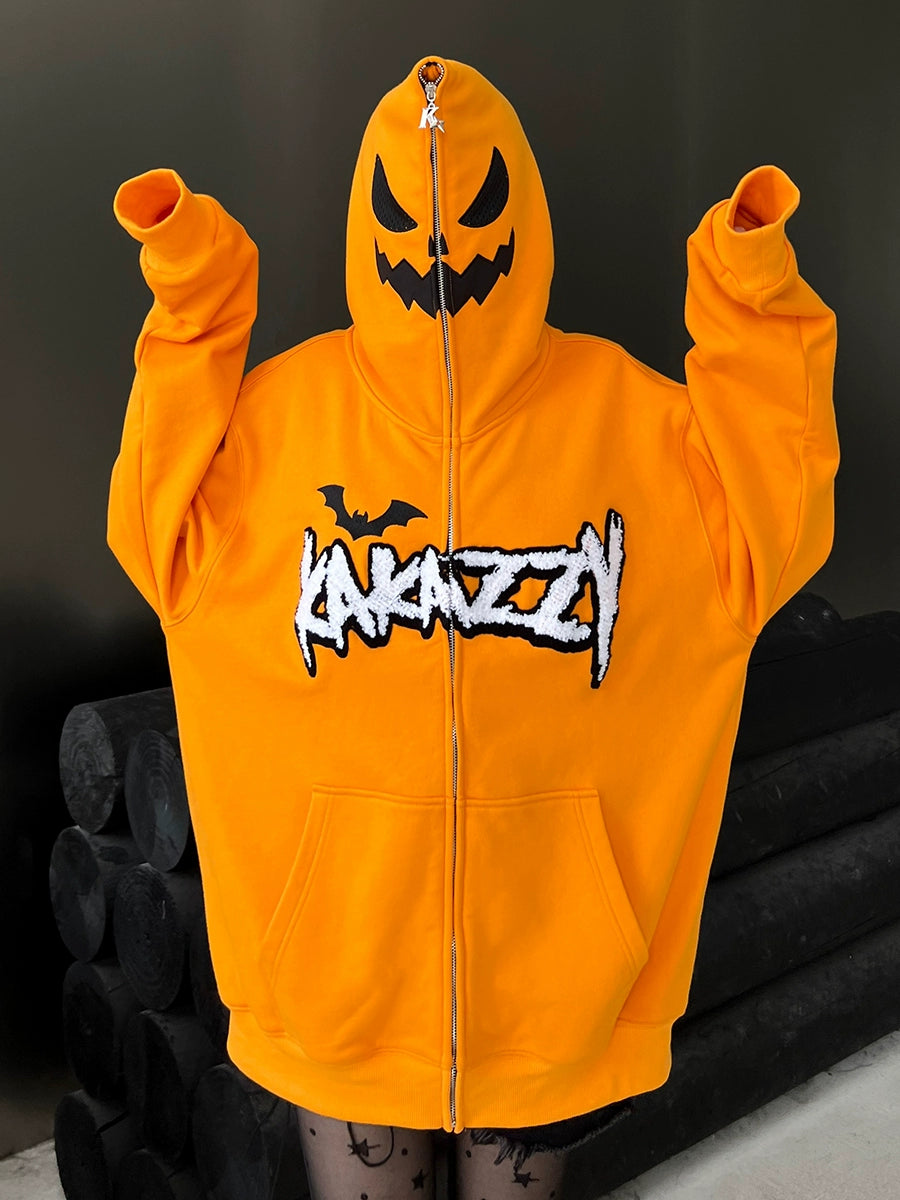 A person wears the Seakoff Halloween Pumpkin Hoodie, an oversized orange zip-up sweatshirt with a black jack-o&
