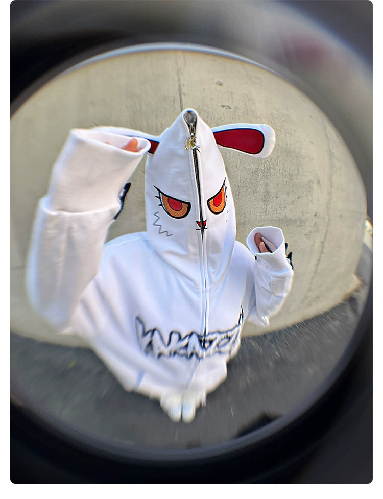 A person wears an oversized Seakoff Fierce Bunny Hoodie made from 400GSM cotton, featuring a rabbit ear design with red eyes and a facial zipper. The word "WATCH" is boldly displayed on the front. Captured via a fisheye lens, the image exhibits striking circular distortion.