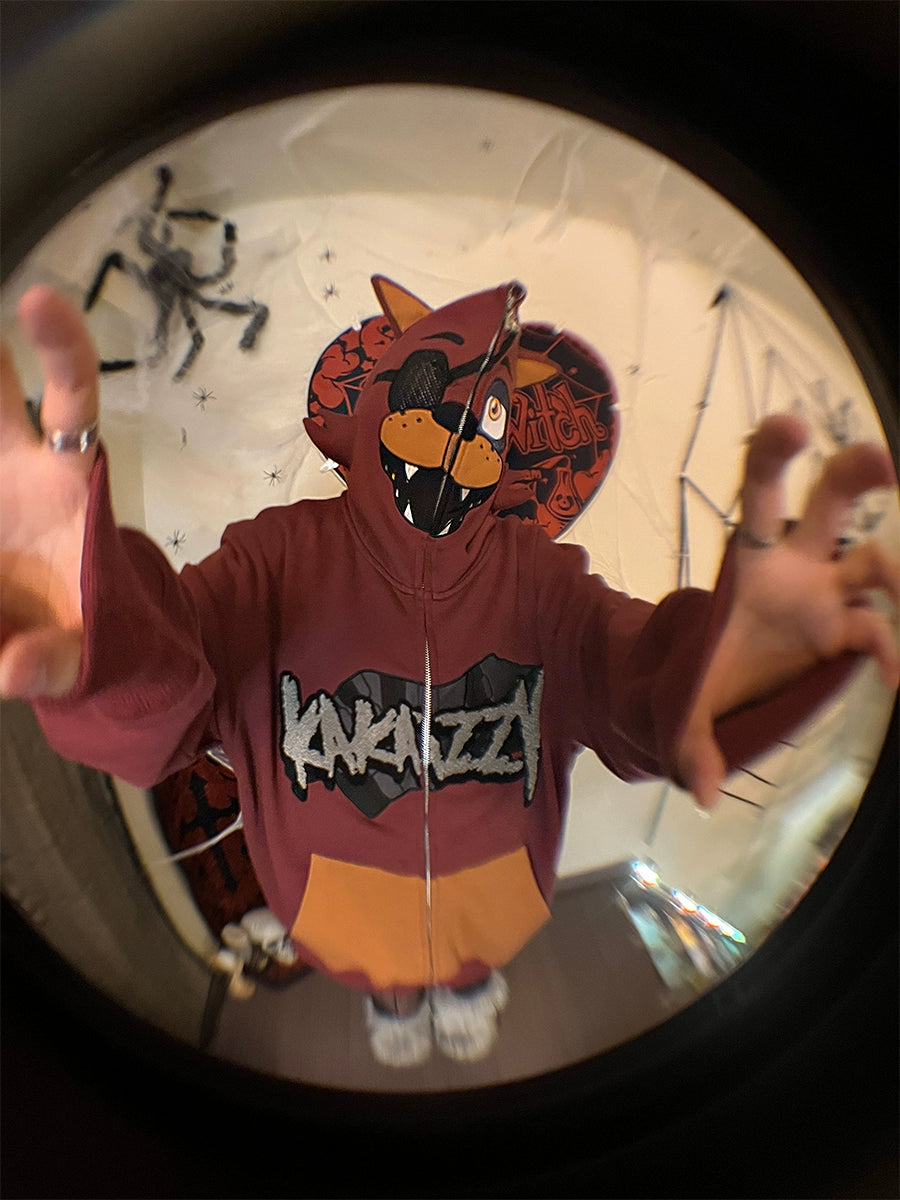 In a Halloween-themed room, someone wears a Seakoff Foxy-Inspired Hoodie—an oversized red zip-up sweatshirt inspired by Five Nights at Freddy&