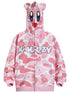 The Seakoff Pink Kirby-Inspired Hoodie features a cartoon face on the hood with large eyes, red mouth, playful 3D ears, white and pink patterns with star motifs, and "KAWAZZY" across the chest over a unique pink camo print. Made from 400GSM cotton.