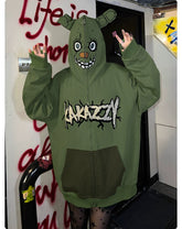Wearing a Seakoff hoodie inspired by Springtrap, with bear ears and a cartoon face on the hood, hands raised. This oversized green zip-up sweatshirt evokes Five Nights at Freddy&