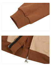 A close-up of a brown cuff on a sleeve from the Seakoff Freddy-Inspired Hoodie showcases this oversized brown and beige zip-up sweatshirt with a distinctive pull tab. Made from 400GSM material, it&