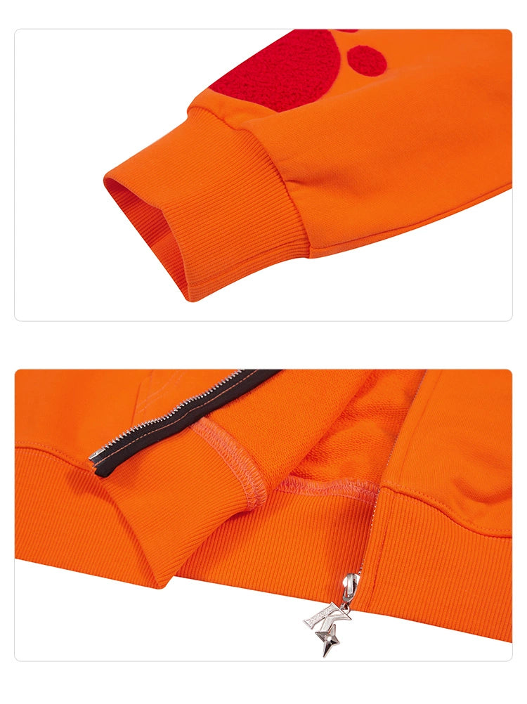 Close-up images of the Seakoff Furious Orange Bear Hoodie detail a red-embroidered sleeve cuff on premium 400GSM cotton (top) and a partially unzipped zipper with a star-shaped charm (bottom).