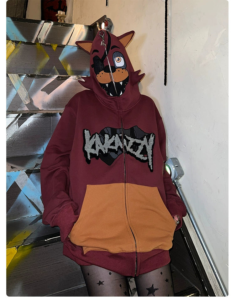 A person stands on stairs wearing a Seakoff Foxy-Inspired Hoodie, an oversized red zip-up sweatshirt with cartoon animal face and ears from Five Nights at Freddy&