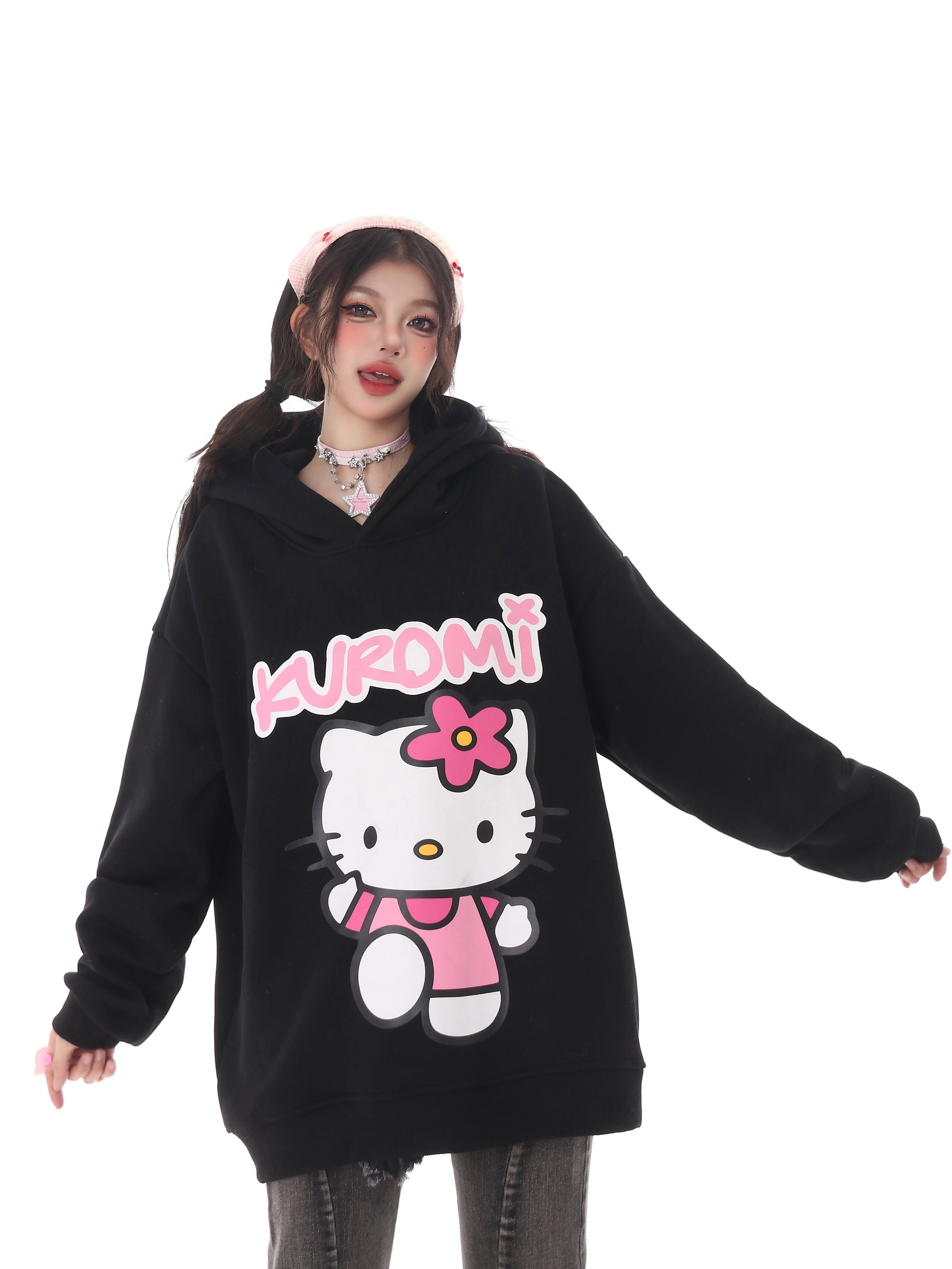 A person in a Seakoff Kawaii Hello Kitty Oversized Hoodie with Kuromi from Sanrio sports a kawaii look. They have long dark pigtails, a pink headband, choker, and gray jeans—ideal for true Sanrio fans.