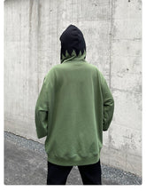 A streetwear enthusiast stands confidently on the asphalt before a concrete wall, donning Seakoff&