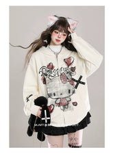 A person wears a cream-colored Seakoff Gothic Hello Kitty Princess Hoodie featuring edgy heart and cross graphics. Paired with a short black skirt, knee-high socks, cat ear headband, long brown hair, and holding a black plush toy, they create an adorable alternative kawaii fashion look.