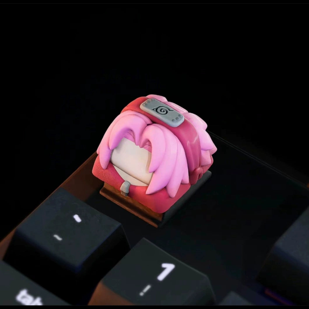 Enhance your keyboard with the Naruto Keycaps Set featuring a premium keycap of a pink-haired character in a gray headband, perfectly placed near the "1" and other black keys. Ideal for anime enthusiasts looking to personalize their setup.