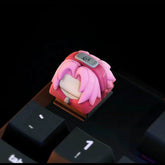 Enhance your keyboard with the Naruto Keycaps Set featuring a premium keycap of a pink-haired character in a gray headband, perfectly placed near the "1" and other black keys. Ideal for anime enthusiasts looking to personalize their setup.