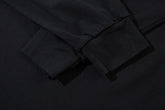 Close-up of the cuff on a Limited Edition Death Note Long Sleeve Shirt - Black & Gray Gradient. The smooth fabric shows visible stitching, with lighting creating slight shadows that highlight the texture of this artistic hem piece from the Death Note brand.
.
