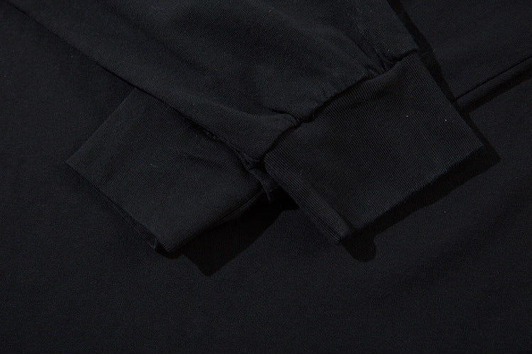 Close-up of the cuff on a Limited Edition Death Note Long Sleeve Shirt - Black & Gray Gradient. The smooth fabric shows visible stitching, with lighting creating slight shadows that highlight the texture of this artistic hem piece from the Death Note brand.
.