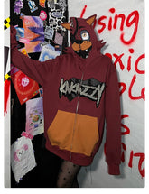 A person in a Seakoff Foxy-Inspired Hoodie, a red 400GSM oversized zip-up with animal ears reminiscent of Five Nights at Freddy&